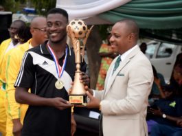 Permanent secretary, Mr. Gabriel Aduda presenting trophy to Enugu State NYSC football team