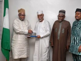 L-R : In a handshake , Surveyor General of the Federation Surv. Abudulganiyu Adeyemi Adebomehin receives the copy of the committee report from the Committee Chairman and Ex Minister of Environment, Surv. Suleiman Hassan Zarma next to him is a member of the committee Surv Umar Nasir and the Registrar of SURCON, Sur. Olugbemiro Olakunle
